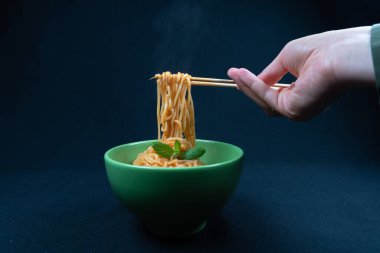 Tavuk Schezwan Eriştesi veya Hakka veya Chow Mein siyah kasede koyu arkaplanda..