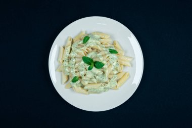 Siyah arka planda pesto makarna tabağı