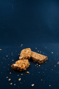 Siyah arkaplanda parçaları olan iki fitness granola barı