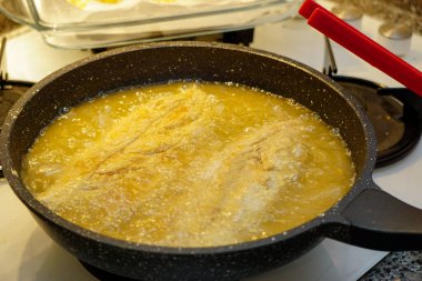 Yağda kızartılmış bonito balığı hazırlığı fırının üstünde gizli resim.