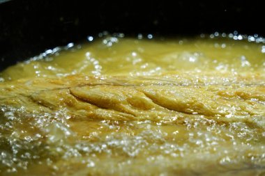 Yağda kızartılmış bonito balığı hazırlığı fırının üstünde gizli resim.