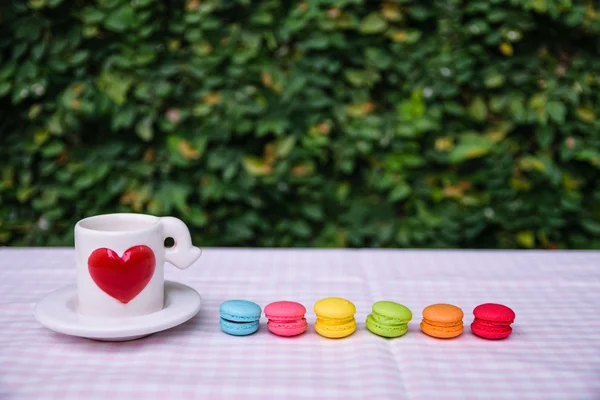 Barevná mini macarons s láskou hrnek — Stock fotografie