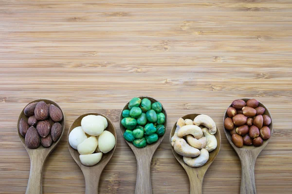 Ahşap arka plan ağaç kaşık karışık Kuruyemiş 