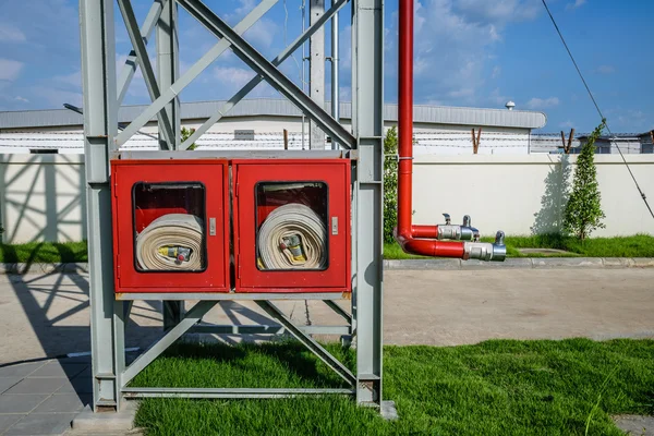 Su hortumları ve yangın söndürme ekipmanları olan yangın musluğu.