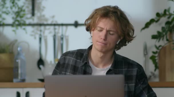 Retrato de joven hombre feliz, el hombre está escuchando música y bailando detrás de la mesa — Vídeos de Stock