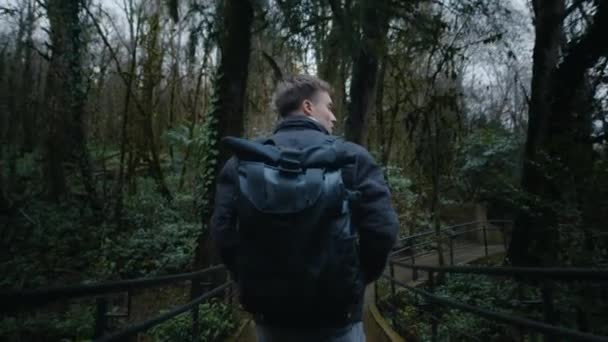 Young guy is walking through the forest, modern freelancer on vacation — Stock Video