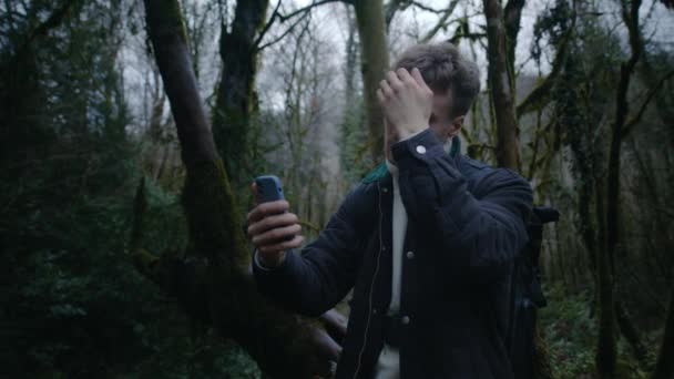 Young guy is taking selfies in forest with phone, Handsome photographer — Stock Video