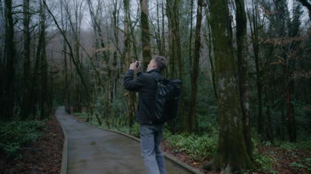 Young male photographer starts his journey in forest, Day walk in the forest — Stock Video