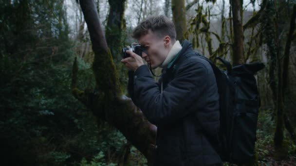 Portret mężczyzny robiącego zdjęcia w lesie, fotograf filmowy w lesie — Wideo stockowe