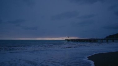 Güzel gün batımının manzarası, kötü havada geniş bir sahilin görüntüsü.