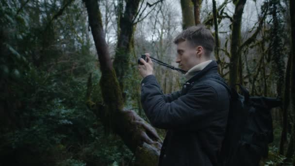 Retrato de tipo tomando fotos en el bosque, fotógrafo moderno en el bosque — Vídeo de stock