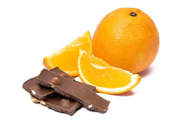 Naranja con una pieza cortada y chocolate — Foto de Stock