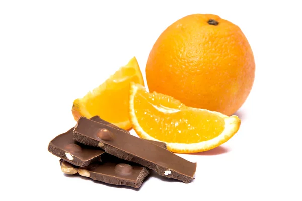 Naranja con una pieza cortada y chocolate — Foto de Stock
