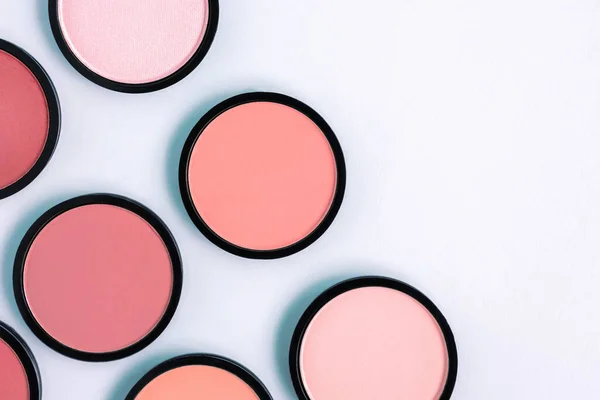 Pastel mavi arka planda pembe allık ve pudra. Pankart. Makyaj. Kozmetik ürünler. Tonal temel. 