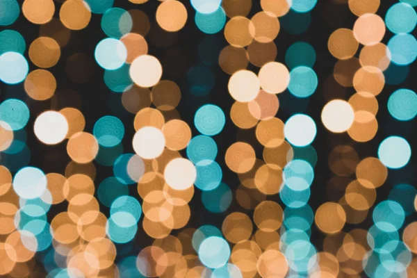 Christmas lights. Festive New Year blurred blue, golden yellow, turquoise and black background. Beautiful sparkling backdrop, texture. Bokeh. Copy space. Place for text. Template. Trendy shades. Xmas.