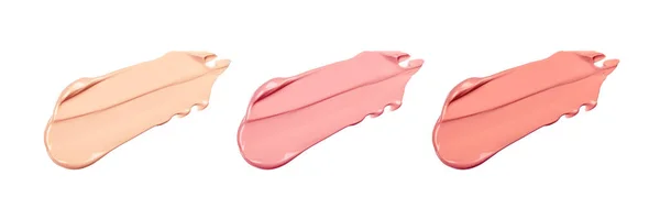 Beyaz arka planda hassas açık bej tonal fondöten lekeleri. Pembe ton lekesi. BB kreminin farklı tonları.