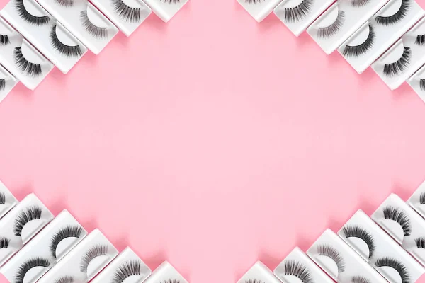 Diferentes pestañas falsas sobre fondo rosa pastel de moda. Patrón de belleza. Accesorios de maquillaje. Productos cosméticos. —  Fotos de Stock