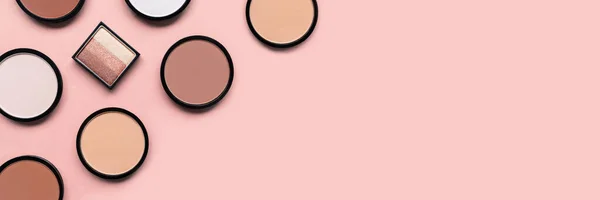 Beige blush, oogschaduw en gezichtspoeder op roze achtergrond. Een spandoek. Make-up. Bruine cosmetische producten. Tone foundation. — Stockfoto