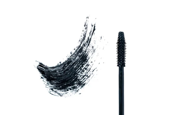 Zwarte smeren mascara en borstel op witte achtergrond. Trendy concept. Geïsoleerd. Maak het goed. Cosmetische producten voor wimpers. — Stockfoto