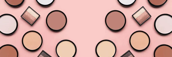 Makeup. Cosmetic products. Beige blush, eyeshadow and compact face powder on pink background. Banner. Tonal foundation. — стоковое фото