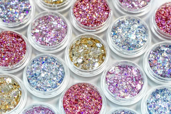 Glitter voor manicure, make-up, nagelverlenging, design. Cosmetische producten. Shimmer in potten op witte achtergrond. — Stockfoto