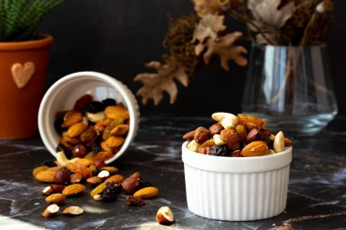 Lezzetli fındık ve kurutulmuş meyve karışımı bir masada, güneşli bir sabah. Sağlıklı gurme vejetaryen doğal atıştırmalık..