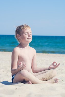 Denize sıfır bir plaj üzerinde meditasyon çocuk