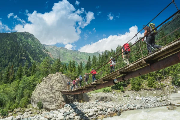 Groupe de randonneurs monte la rivière de montagne — Photo