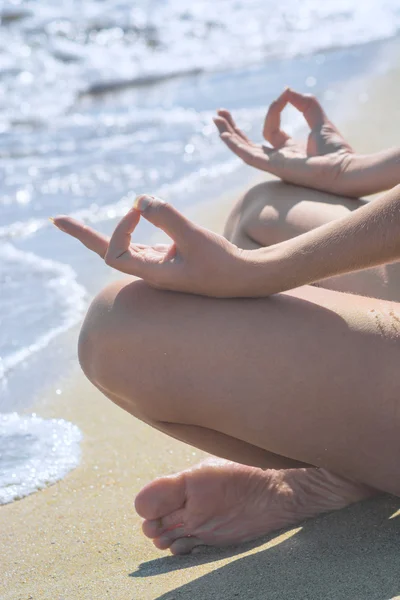 Mulher relaxando praticando ioga na praia — Fotografia de Stock