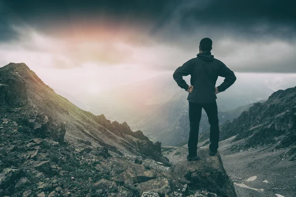 Caminante se queda en la cima de una montaña — Foto de Stock