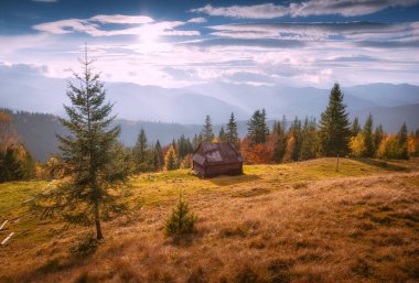 Gün batımında Karpatlar 'daki yeşil bir çayırda Shepherd' ın evi..