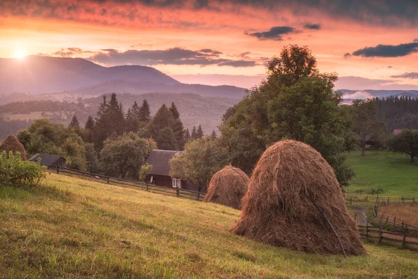 黄昏时分 海草堆在草地上 天空中笼罩着雄伟的红云 美丽的田园风光 喀尔巴阡山脉 乌克兰 — 图库照片