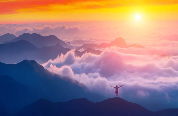 Hombre de pie en la cima de una montaña — Foto de Stock