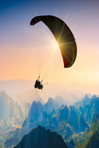 Paragliden over bergtoppen. — Stockfoto