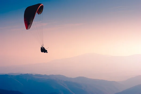 Paraglide silhouette over  mountain valley. — Stock Photo, Image