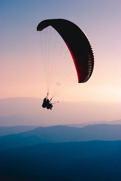 Paraglide silhouette over  mountain valley. — Stock Photo, Image