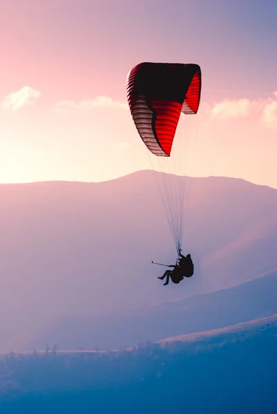 Silhueta de parapente sobre vale de montanha . — Fotografia de Stock