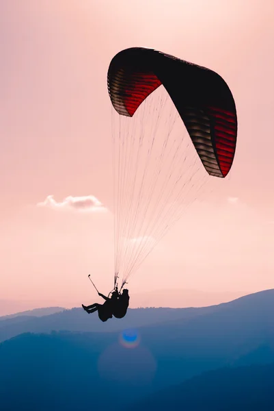 Silhueta de parapente sobre a montanha — Fotografia de Stock