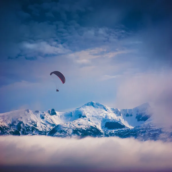 Parapente acima dos picos cobertos de neve — Fotografia de Stock