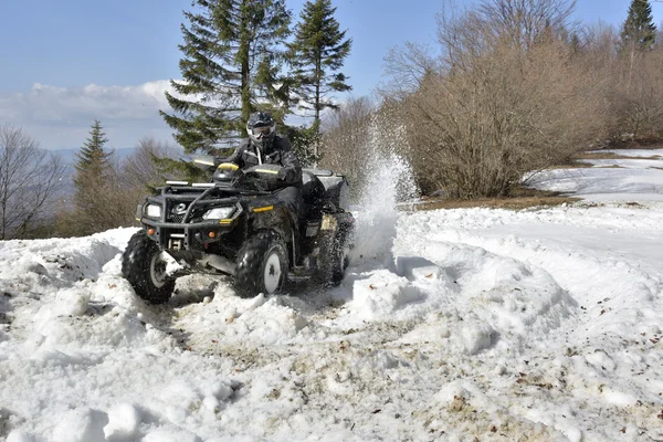 Homem dirigindo uma moto quad no campo de inverno — Fotografia de Stock