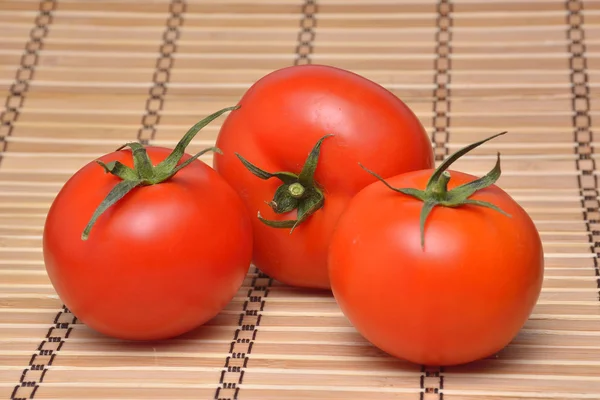 Tomatoes on rustic wooden background — Stock Photo, Image