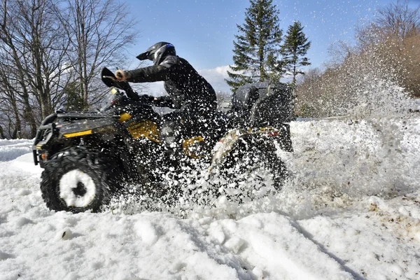 Άνθρωπος οδήγηση ενός quad bike στο πεδίο χειμώνα — Φωτογραφία Αρχείου