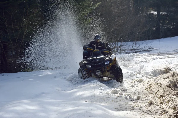 adam kış alanında bir quad bisiklet sürüş 