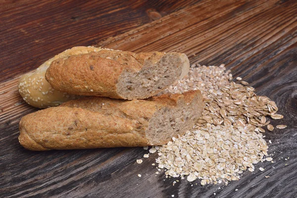 Brot und Körner auf Holzgrund — Stockfoto