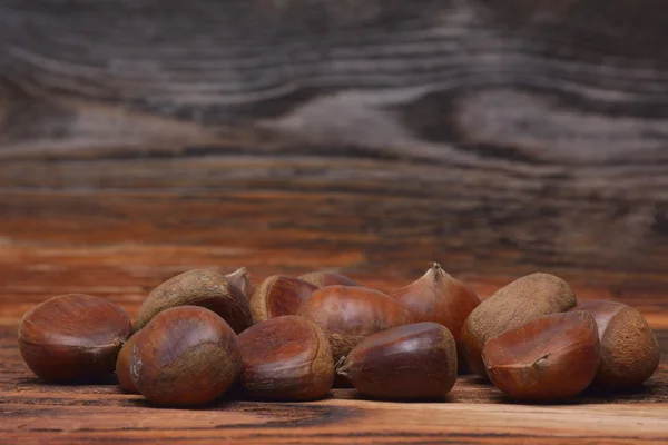 Castanhas em fundo de madeira — Fotografia de Stock