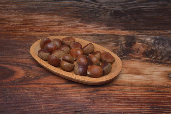 Chestnuts on wooden background — Stock Photo, Image