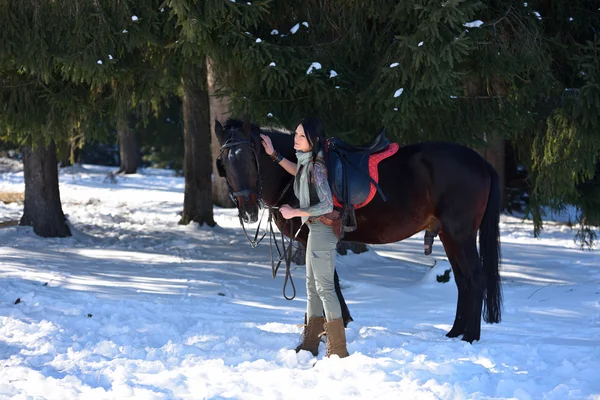 Mujer joven a caballo al aire libre en invierno — Foto de Stock