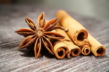 Gri masa örtüsündeki baharatlar: tarçın çubukları ve Anise Yıldızı