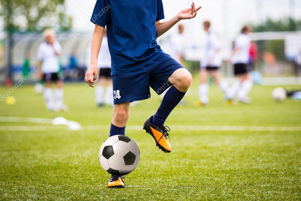 Boy Playing Soccer Football Match on a Sports Stadium