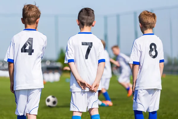 Equipo de fútbol juvenil; Reserva jugadores en un banco; Niños listos para jugar —  Fotos de Stock